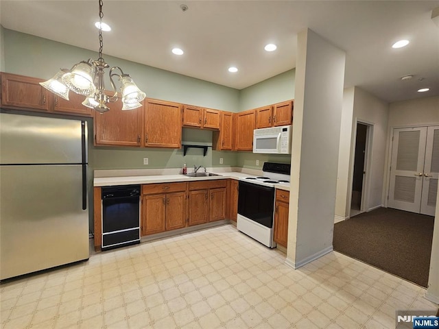 kitchen featuring electric stove, hanging light fixtures, stainless steel fridge, sink, and a chandelier