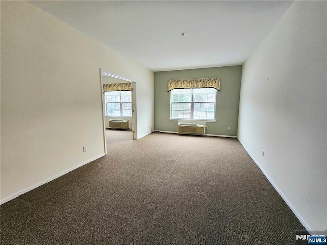 carpeted spare room with a wall unit AC