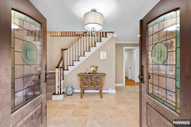 foyer entrance with a baseboard heating unit, a healthy amount of sunlight, and crown molding