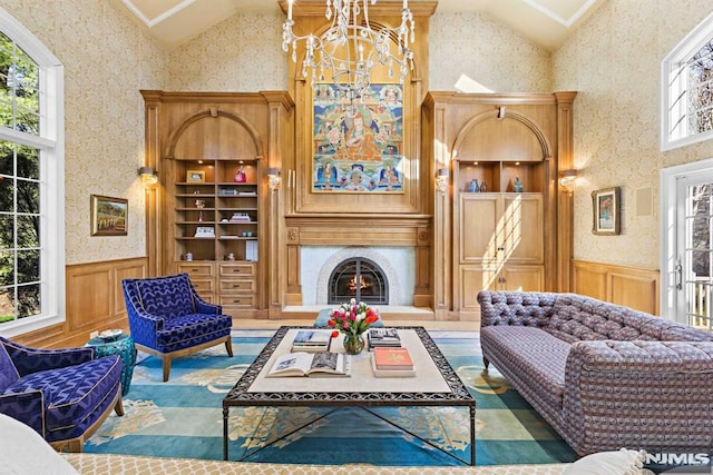 living room featuring high vaulted ceiling, built in shelves, and an inviting chandelier