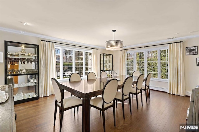 dining area with dark hardwood / wood-style floors, ornamental molding, and a baseboard radiator