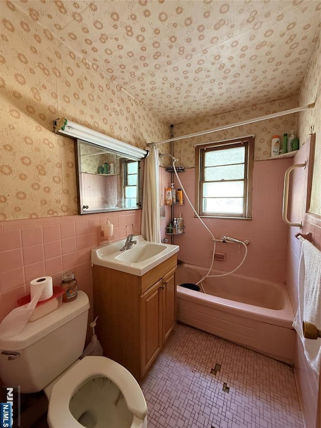 full bathroom featuring vanity, tile walls, shower / tub combo with curtain, and toilet