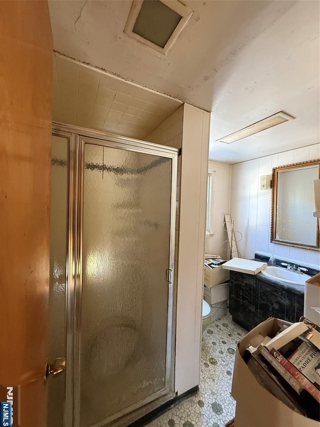 bathroom with a shower with door and toilet