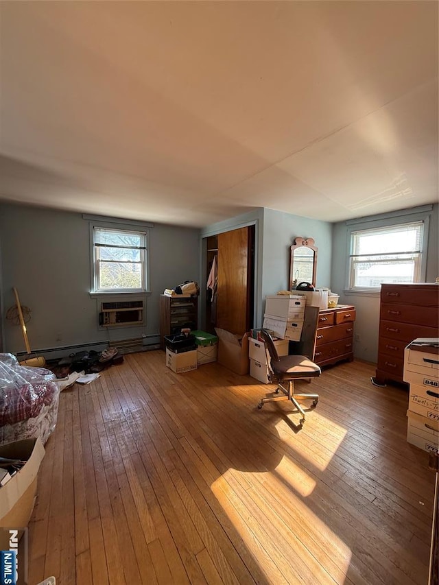 living area featuring a wall mounted air conditioner and hardwood / wood-style floors