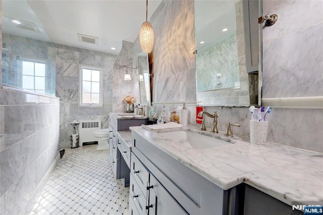 120 Prospect Ave, Hackensack, NJ 07601 - bathroom with tile walls, vanity, radiator heating unit, and toilet