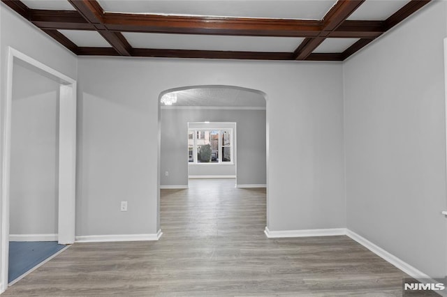 spare room with light wood-type flooring, beam ceiling, and coffered ceiling