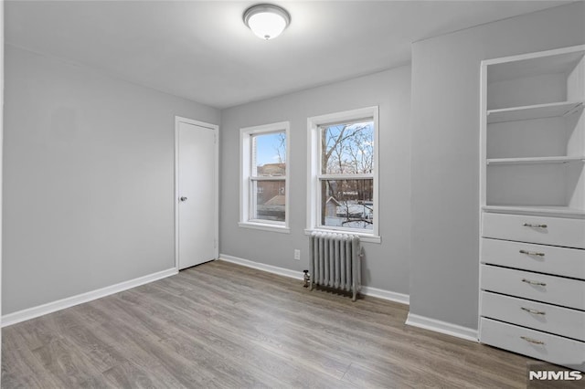 interior space with radiator heating unit and light wood-type flooring