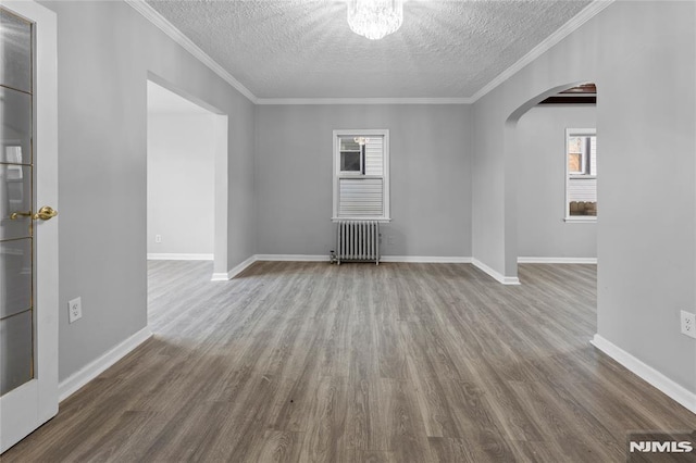 unfurnished room featuring wood-type flooring, a textured ceiling, and radiator heating unit