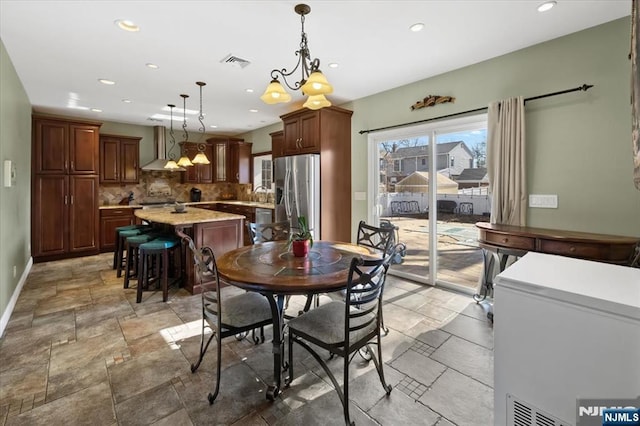 dining space featuring stone tile flooring, visible vents, recessed lighting, and baseboards