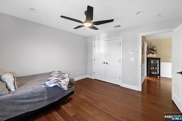 bedroom featuring visible vents, baseboards, ceiling fan, wood finished floors, and a closet