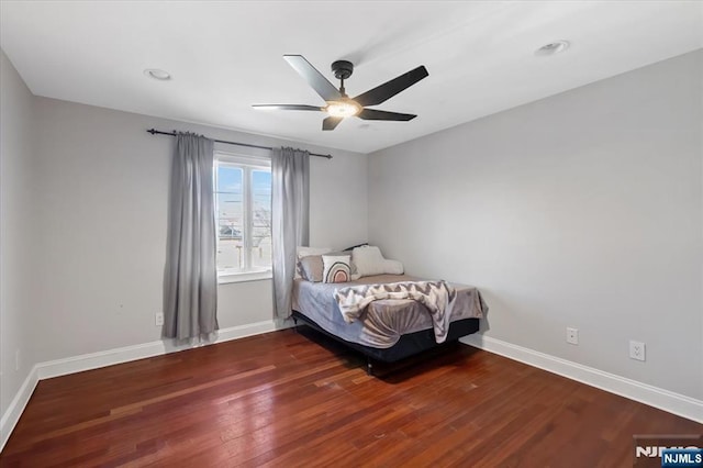 bedroom with ceiling fan, baseboards, and wood finished floors