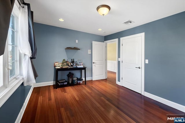 empty room featuring recessed lighting, visible vents, baseboards, and wood finished floors