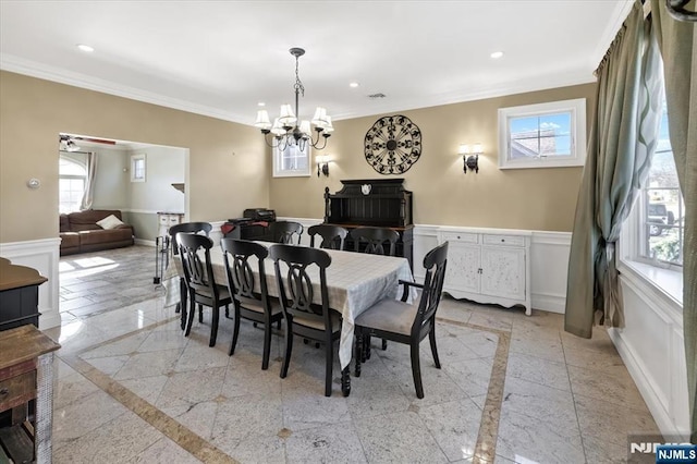 dining area with a wainscoted wall, recessed lighting, baseboards, and ornamental molding