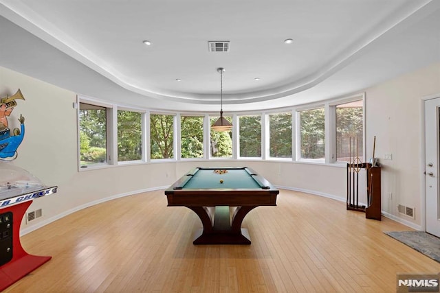 playroom with a raised ceiling, billiards, a healthy amount of sunlight, and light hardwood / wood-style floors