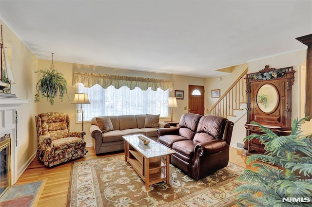 living room with a high end fireplace and light wood-type flooring