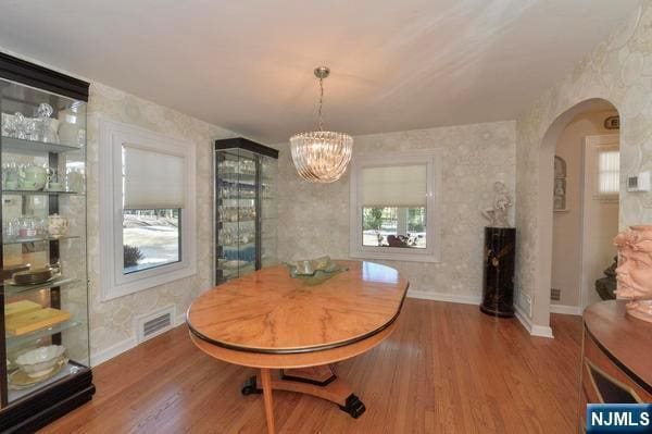 dining room with wood-type flooring and a chandelier