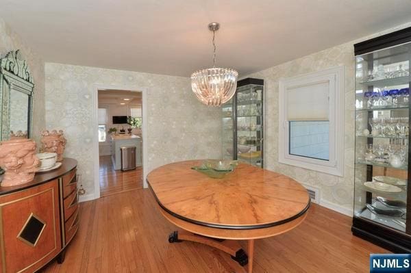 dining space featuring hardwood / wood-style floors and a notable chandelier