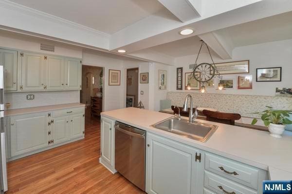 kitchen featuring sink, hanging light fixtures, ornamental molding, stainless steel dishwasher, and light wood-type flooring
