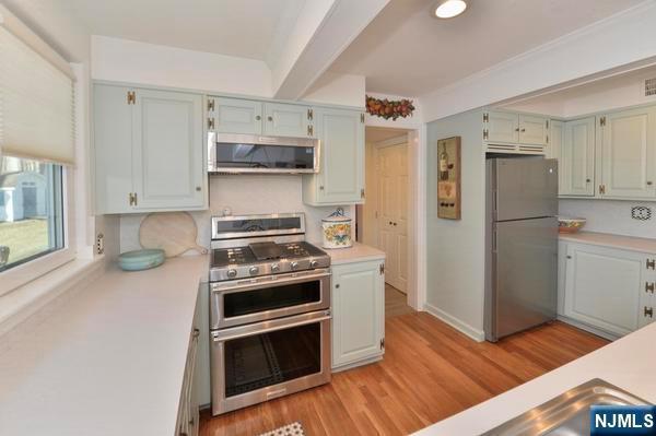 kitchen featuring stainless steel appliances, exhaust hood, and light wood-type flooring