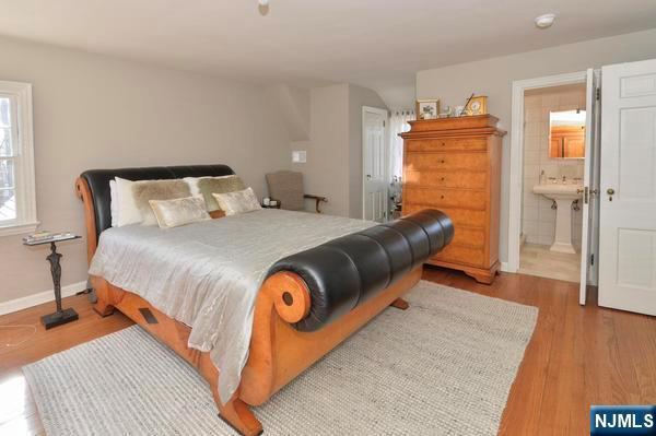 bedroom featuring connected bathroom and light hardwood / wood-style flooring
