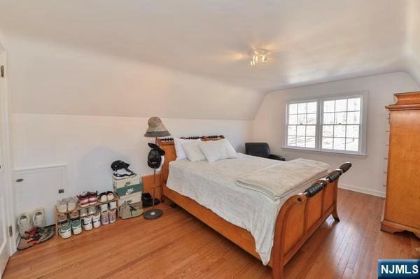 bedroom featuring wood-type flooring and vaulted ceiling