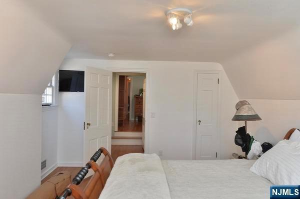 bedroom with hardwood / wood-style flooring and lofted ceiling
