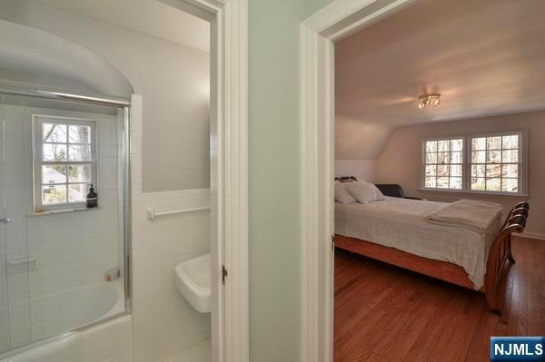 bedroom with hardwood / wood-style flooring and vaulted ceiling
