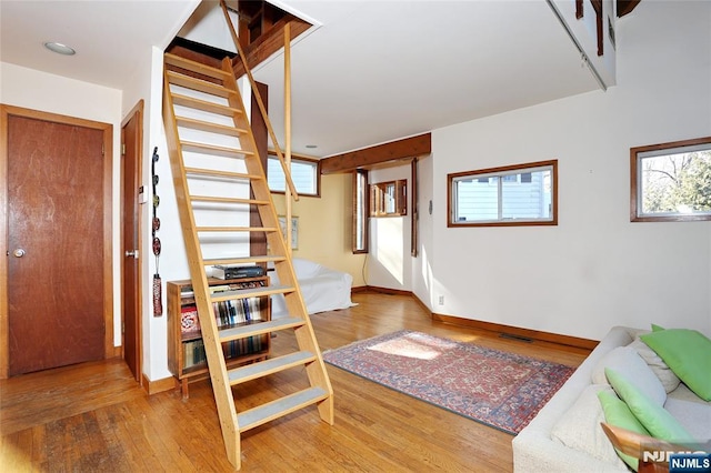 interior space with a wealth of natural light, visible vents, baseboards, and wood finished floors