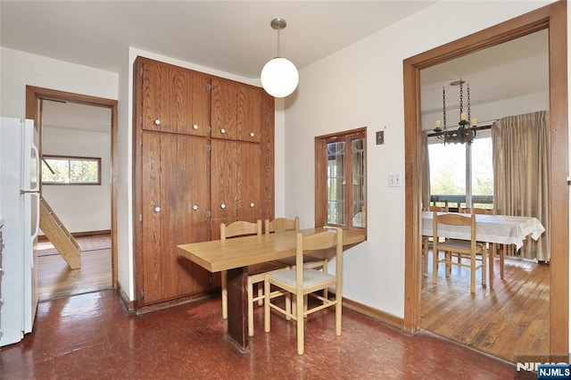 dining room with a chandelier, a healthy amount of sunlight, and baseboards