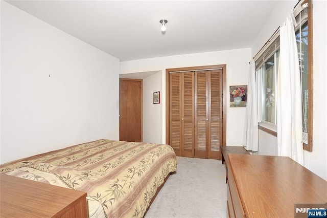 bedroom featuring light carpet and a closet