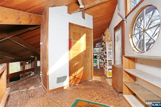 interior space with lofted ceiling with beams, wooden ceiling, and visible vents