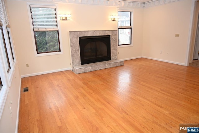 unfurnished living room featuring light hardwood / wood-style flooring and a fireplace