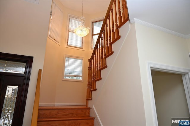 stairs with a chandelier and a high ceiling