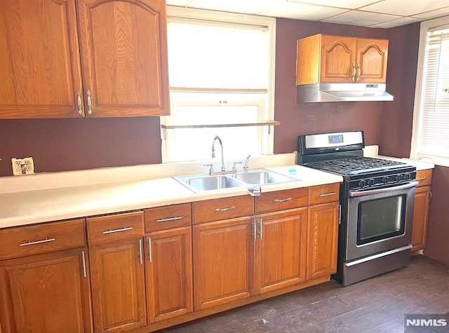 kitchen with dark wood-type flooring, sink, a paneled ceiling, and stainless steel range with gas stovetop