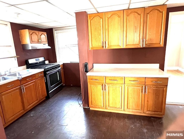 kitchen featuring gas range, sink, a drop ceiling, and dark hardwood / wood-style flooring