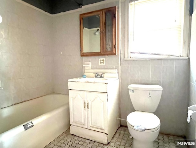 bathroom with toilet, a bathing tub, tile walls, and vanity