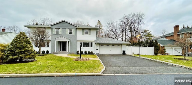 view of front of property with a garage and a front lawn