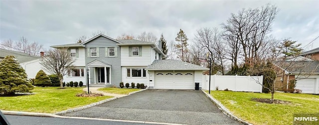 view of property featuring a garage and a front lawn