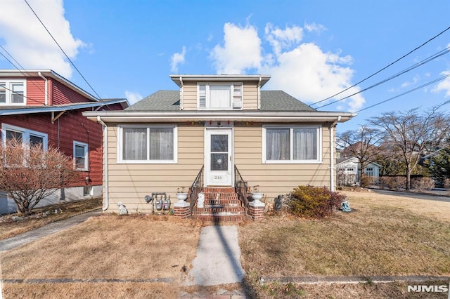 bungalow-style home with a front yard