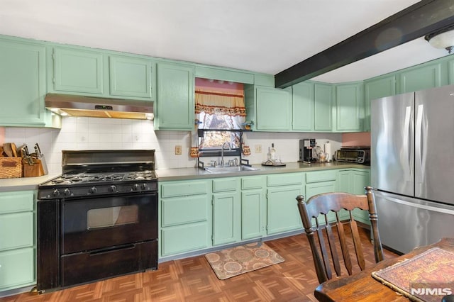 kitchen featuring stainless steel refrigerator, sink, black range with gas stovetop, green cabinetry, and beam ceiling