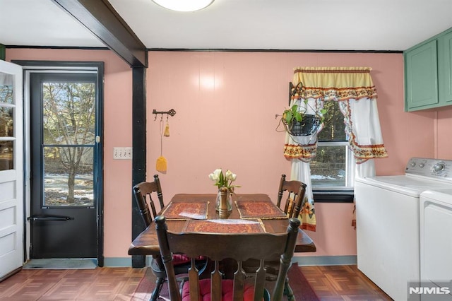 dining area featuring dark parquet flooring and washing machine and dryer