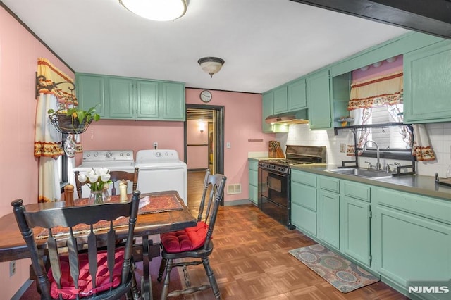 kitchen featuring separate washer and dryer, sink, dark parquet flooring, green cabinets, and black range with gas cooktop