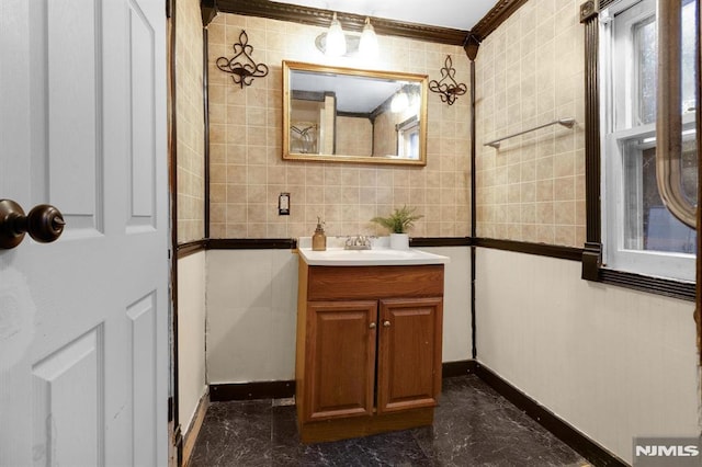 bathroom with tile walls, vanity, and crown molding