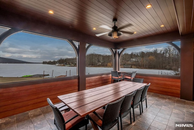 patio terrace at dusk with ceiling fan and a water view