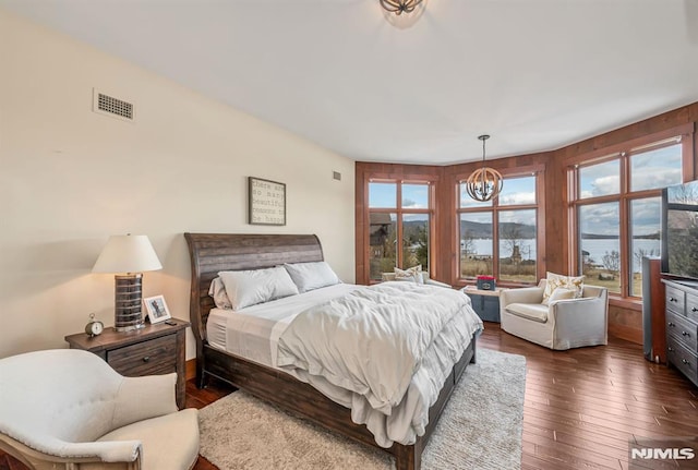 bedroom featuring dark hardwood / wood-style floors and a chandelier