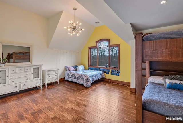 bedroom with dark hardwood / wood-style floors, lofted ceiling, and a chandelier