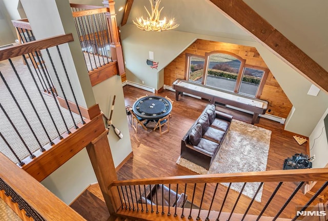 living room with baseboard heating, a chandelier, a towering ceiling, and beamed ceiling