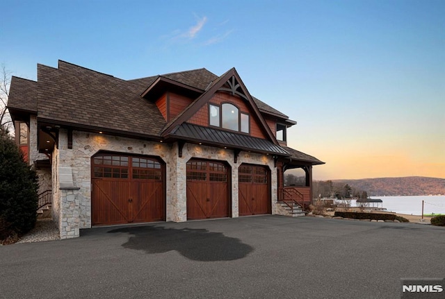 view of front of home with a garage and a water view