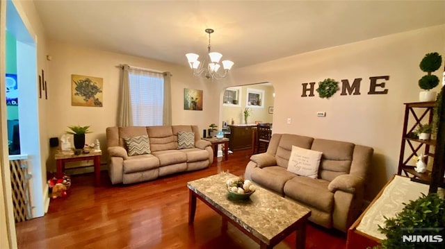 living room with a baseboard heating unit, dark hardwood / wood-style flooring, and an inviting chandelier