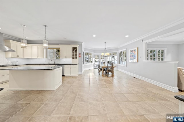 kitchen with backsplash, a chandelier, stainless steel dishwasher, light tile patterned floors, and crown molding